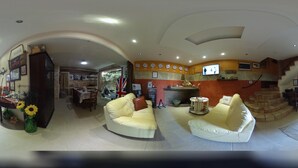 A spacious living area with two white sofas, a fireplace, and a television mounted on the wall. - La Corte Normanna (Sciacca)