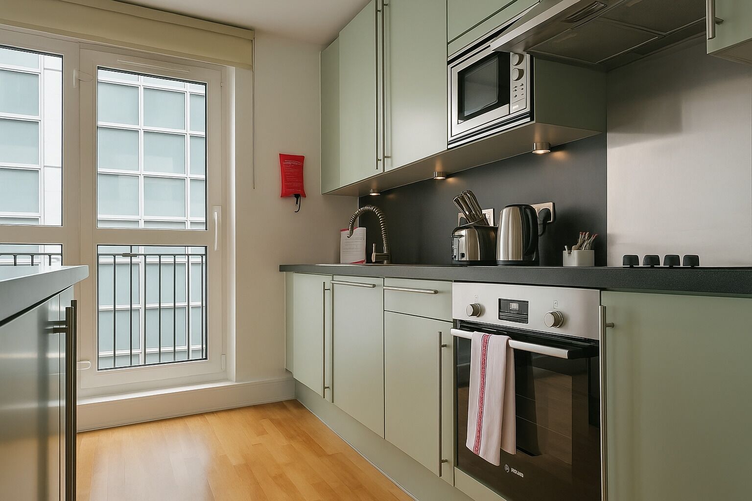 A modern kitchen with a microwave, oven, and stainless steel appliances.