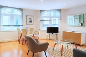 Apartamento executivo, 1 quarto | Área de estar | TV de tela plana