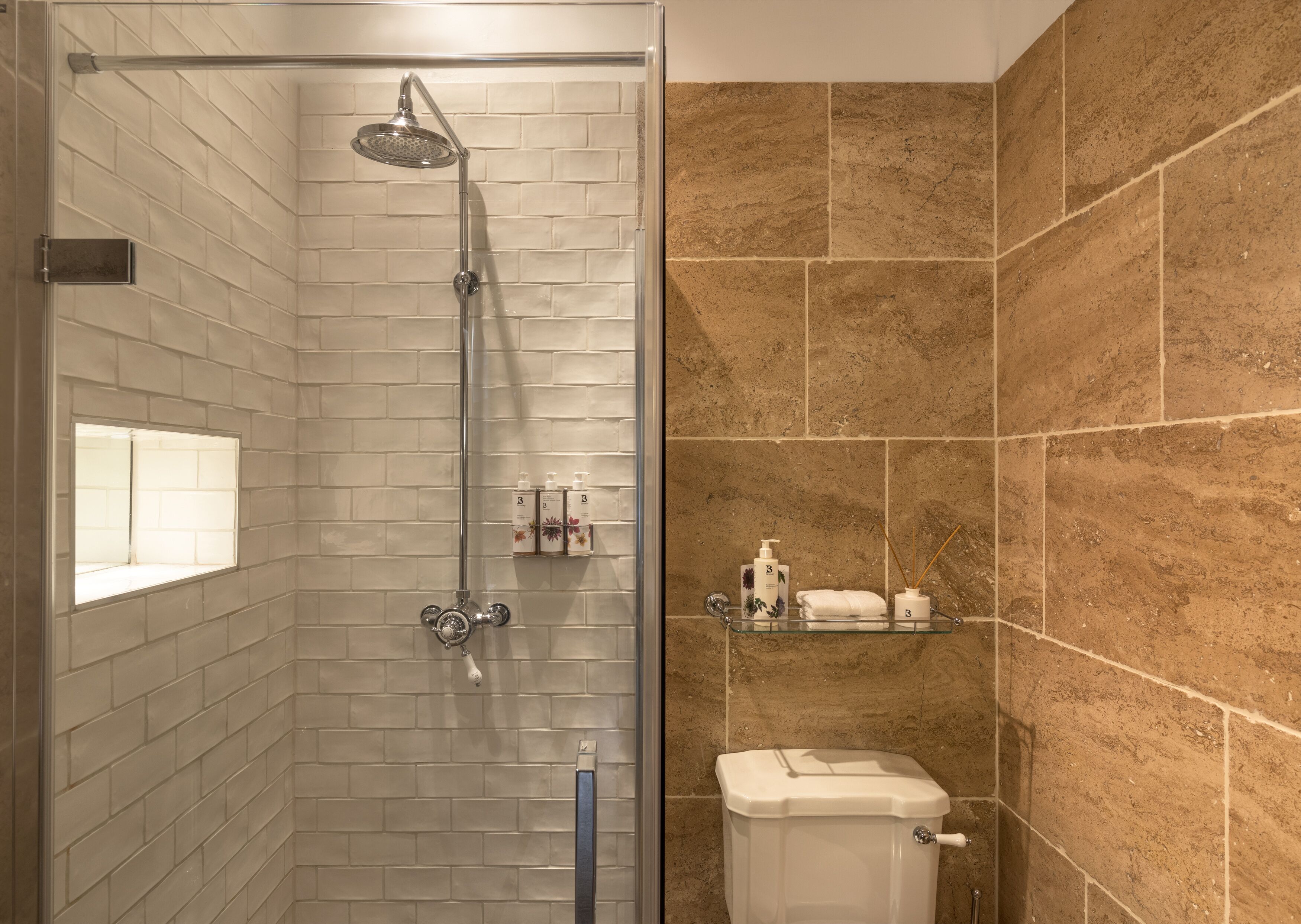 Ein Badezimmer mit Dusche, Toilette und Fliesen.