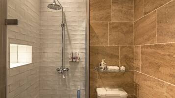 Ein Badezimmer mit Dusche, Toilette und Fliesen.