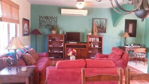 A living room with a sofa, TV, bookshelf, and decorative items. - FN460- Charming Cozy Luxury Villa (Loreto)