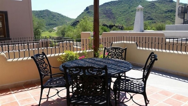 A terrace with a round table and four chairs, surrounded by a metal railing, overlooking a mountainous landscape. - FN460- Charming Cozy Luxury Villa (Loreto)