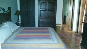 A hotel room with a bed, a wooden wardrobe, a trash bin, and a lamp. - FN460- Charming Cozy Luxury Villa (Loreto)