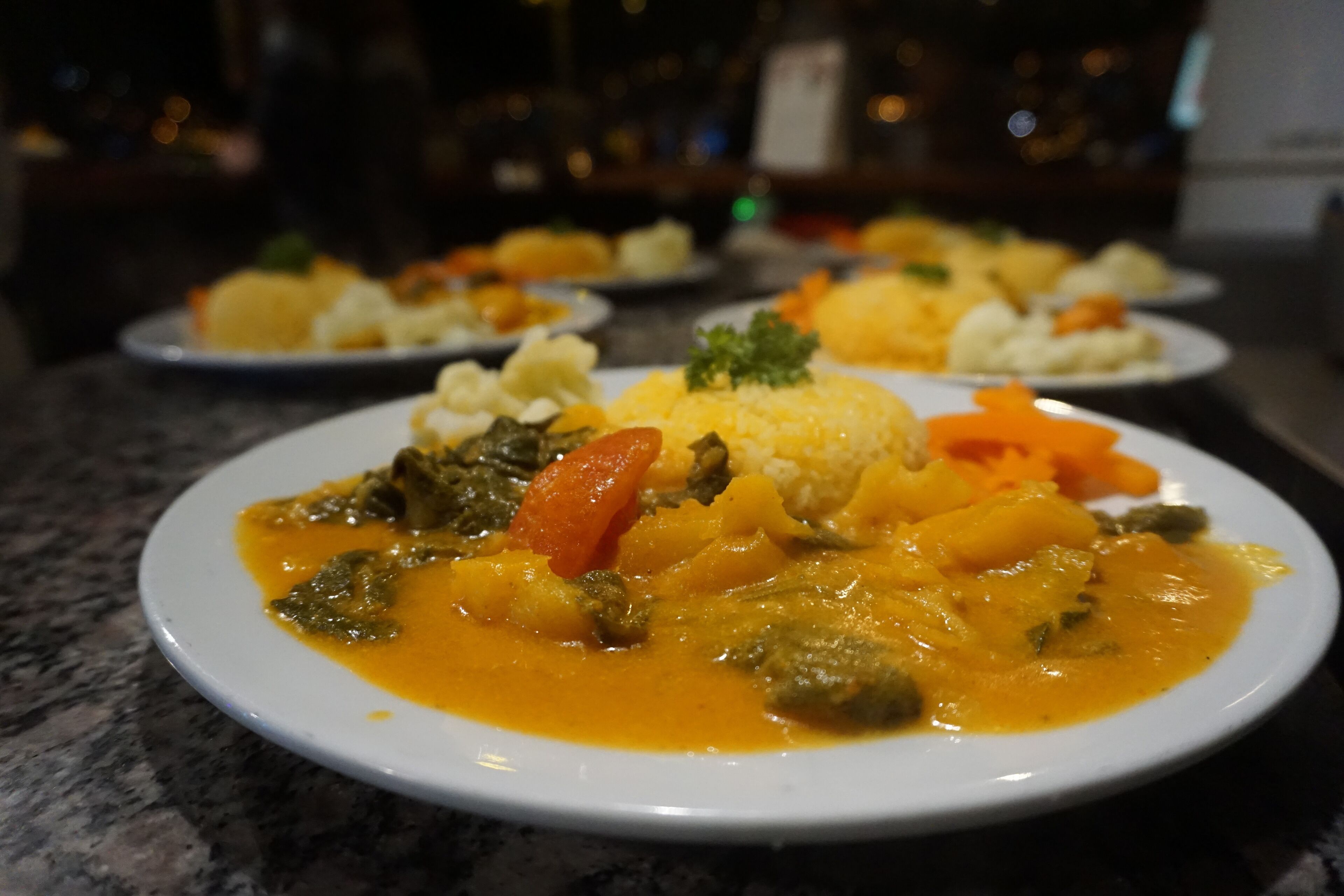 Prato de comida com diversos vegetais e molho cremoso.