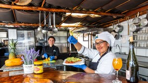 Une cuisine avec un comptoir en bois, un ananas et une bouteille d’huile d’olive.