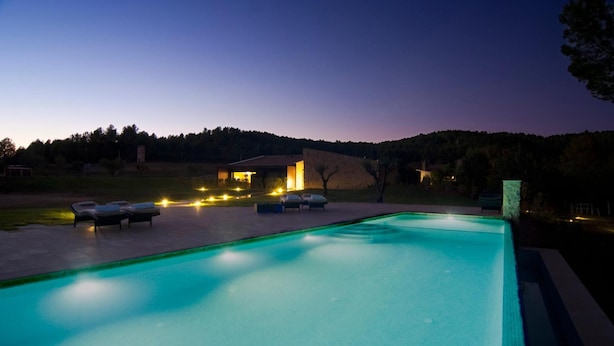 A swimming pool with lounge chairs and a building in the background. - Hotel Restaurant el Molí (Pont de Molins)