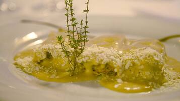Une assiette de nourriture garnie d’herbes fraîches et de fromage râpé.