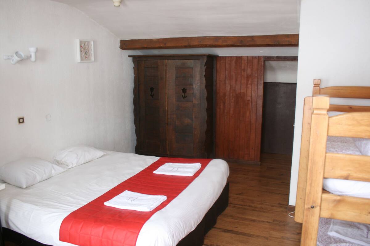Une chambre à coucher avec un lit, une armoire en bois et un banc en bois.