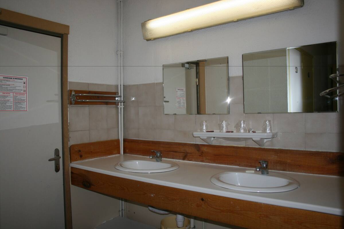 Une salle de bain avec deux lavabos, un miroir et un porte-serviettes.