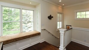 A staircase with a white handrail and a bench at the top. - Douglas Manor (Douglas)