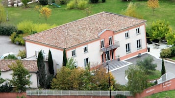 Experience the charm of Le Domaine Des Vignes, a serene hotel surrounded by lush gardens and a beautifully manicured lawn.