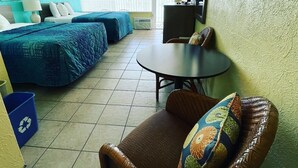 A hotel room with two beds, a dining table, and a chair. - Bird Of Paradise Motel (North Wildwood)