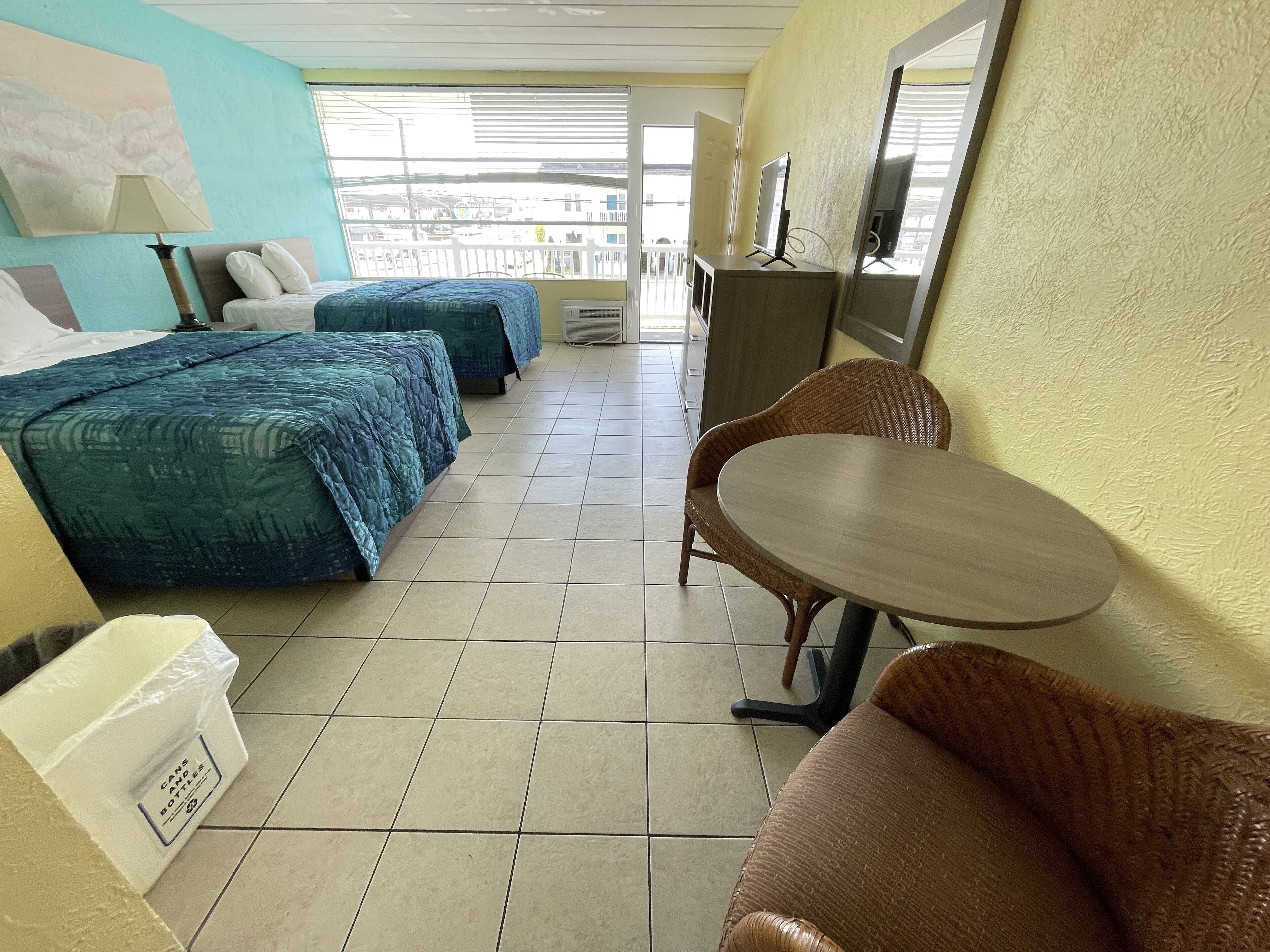 Habitación de hotel con dos camas, una mesa y una silla.