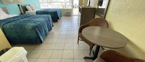 Habitación de hotel con dos camas, una mesa y una silla.