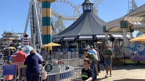 A bustling amusement park with a Ferris wheel, a roller coaster, and a lighthouse attraction. - Bird Of Paradise Motel (North Wildwood)