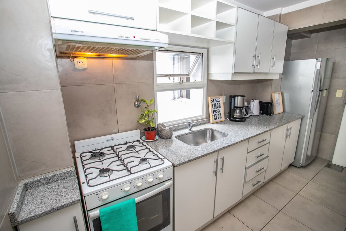 A modern kitchen with a gas stove, stainless steel appliances, and a granite countertop.