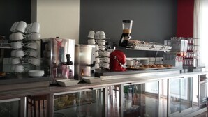 A buffet setup with various food items and a coffee station. - Hostal Comercio (Denia)