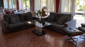 A spacious living area with two grey sofas, a glass coffee table, and a modern lamp. - Hostal Comercio (Denia)