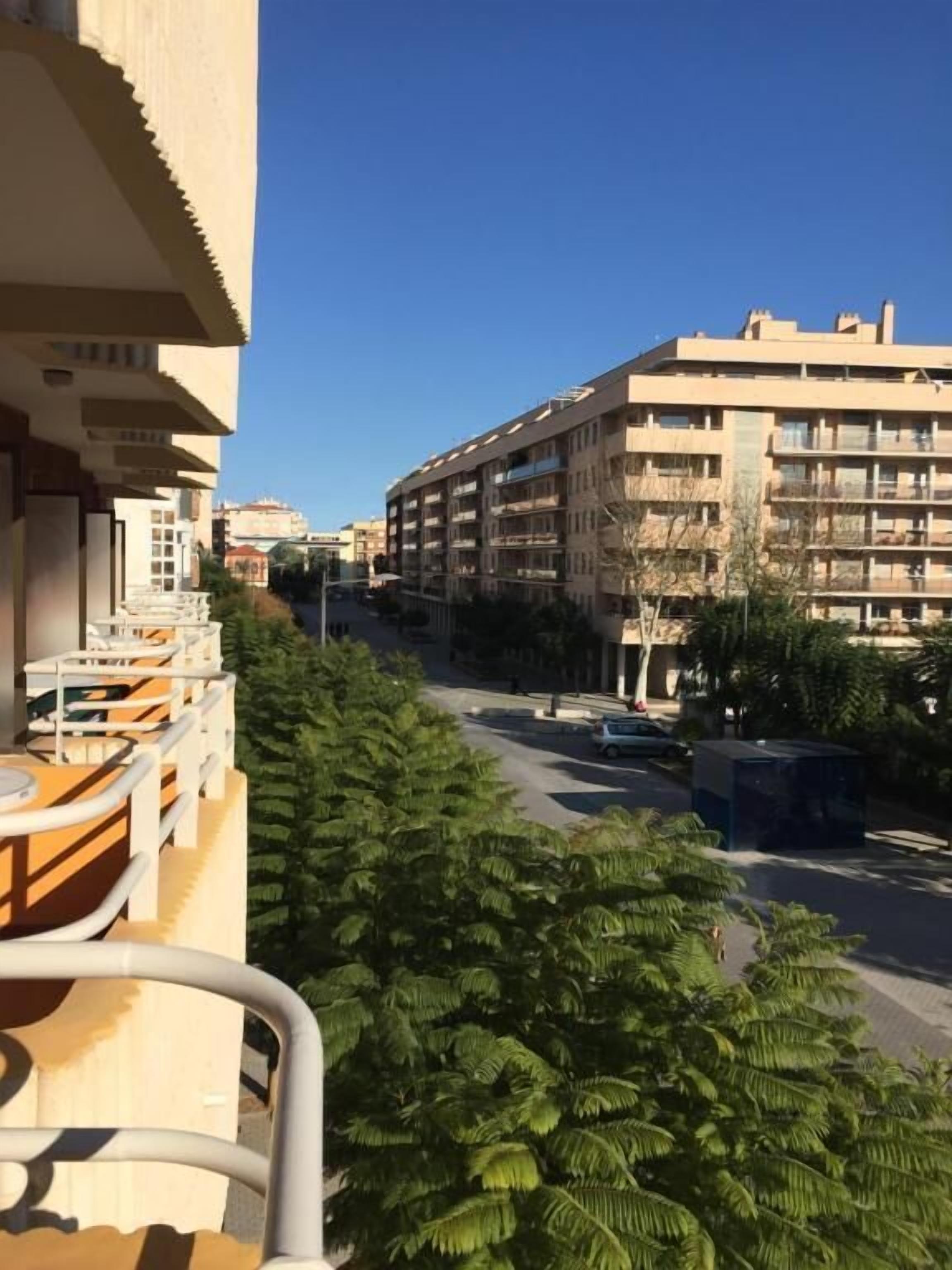 A residential building with multiple balconies and a clear view of the street.