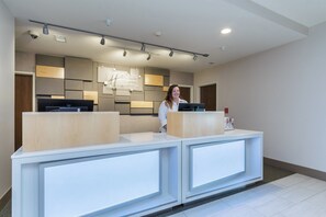 A reception desk with a modern design, featuring a flat surface and integrated lighting. - Holiday Inn Express & Suites - South Bend Casino  by IHG (South Bend)