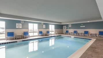 An indoor swimming pool with clear signage, including a 'No Diving Allowed' sign and a 'Maximum Bather Load' sign.