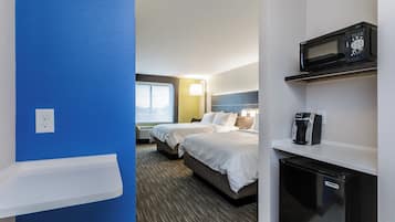 A hotel room with a bed, a microwave, a coffee maker, and a window with a view.