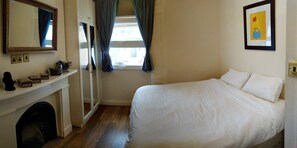 Un dormitorio con cama, cómoda, espejo, ventana con cortinas y un cuadro en la pared.