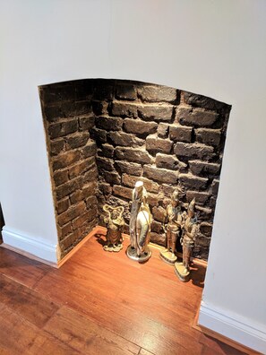 Una esquina con pared de piedra y suelo de madera.