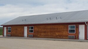 Un bâtiment en bois doté d’un toit en pente, de deux fenêtres visibles et d’une porte.