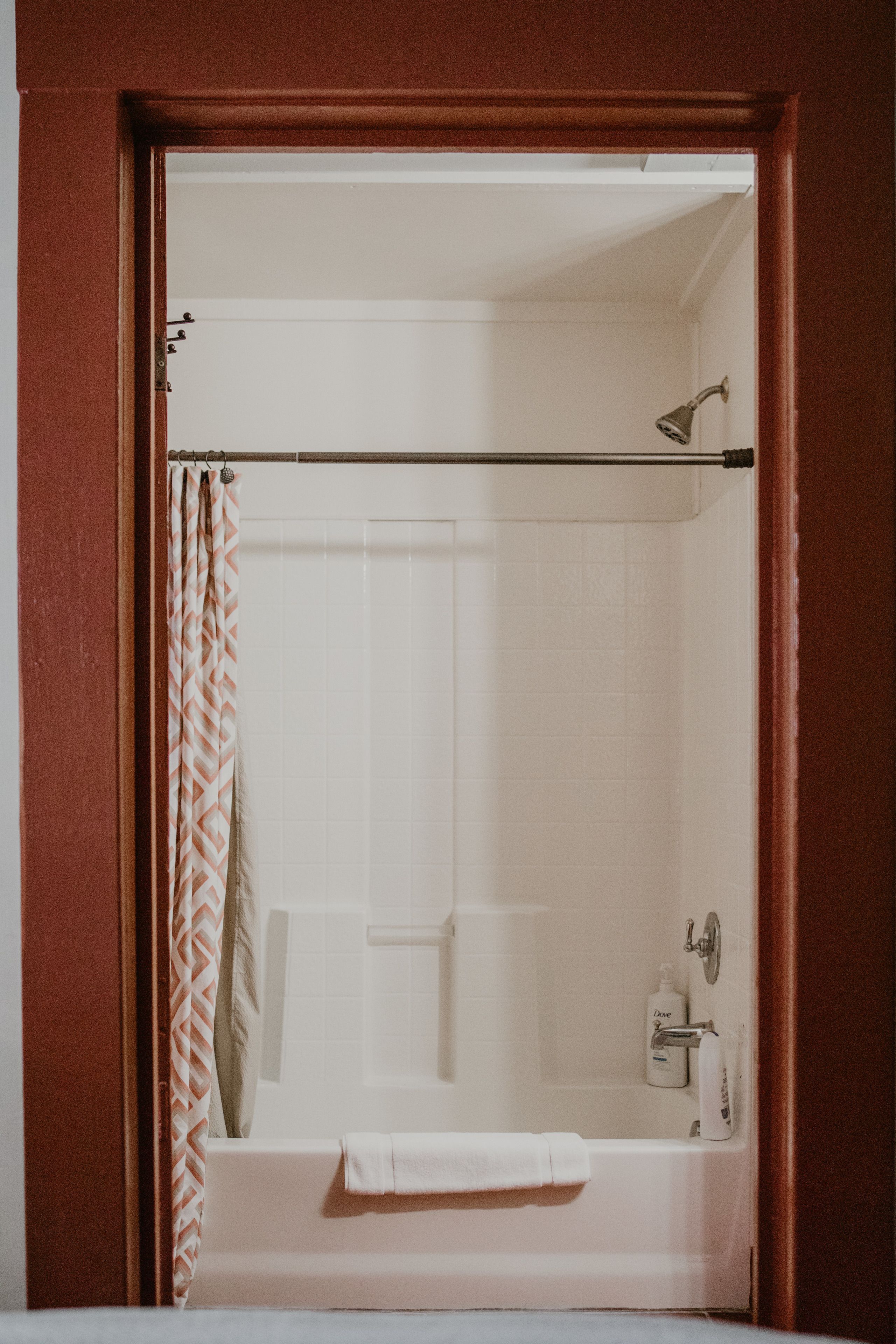 A bathroom with a shower, a bathtub, and a towel rack.