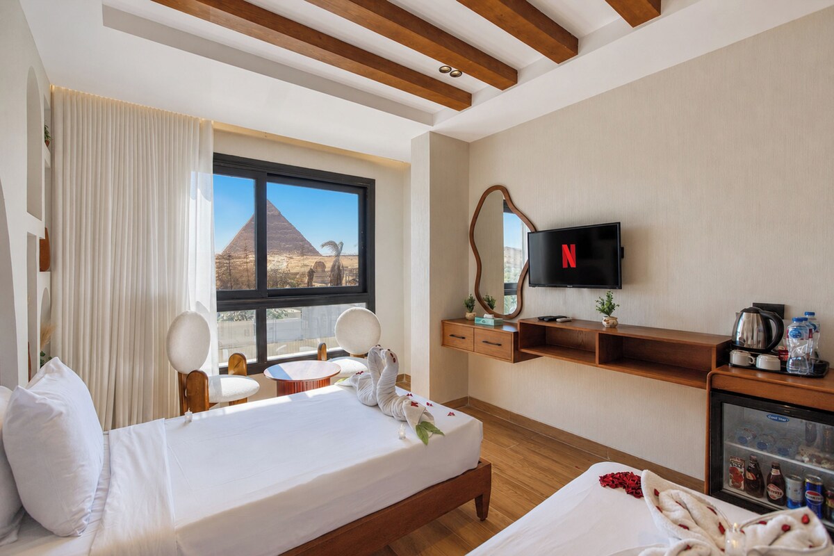 A hotel room with a bed, a desk, a television, and a minibar.