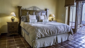 A bedroom with a large bed, two bedside tables with lamps, and a view of the outside through a window with a view to the outside. - FN118-Loreto Bay-Artistic Cozy Villa (Loreto)