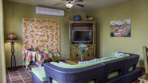 A living room with a sofa, a television, a lamp, and a painting on the wall. - FN118-Loreto Bay-Artistic Cozy Villa (Loreto)