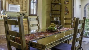 A dining area with a wooden table and chairs, a chandelier, and a kitchen in the background. - FN118-Loreto Bay-Artistic Cozy Villa (Loreto)