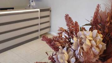 A reception area with a reception desk, a monitor, and a logo for Igaras Hotel.