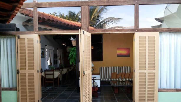 A house with open doors leading to a dining area and a living room. - Casa das Orquídeas (Arraial do Cabo)