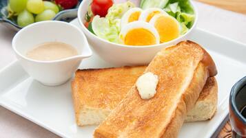 A plate with toasted bread, a salad, and a small bowl of sauce.