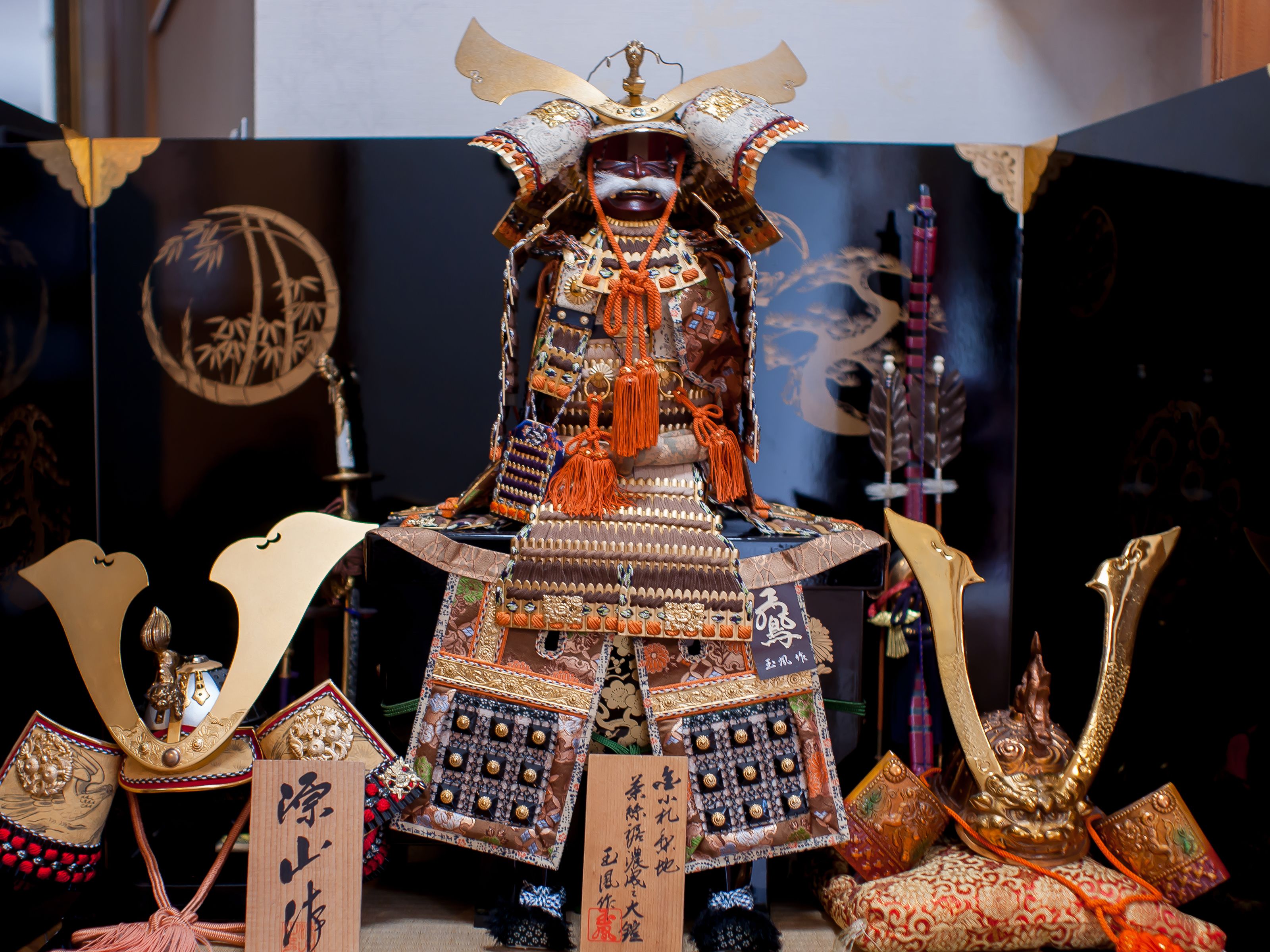 Una exhibición de armadura samurai tradicional con diseños intrincados y caligrafía.