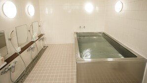 A bathroom with a large bathtub, two sinks with mirrors, and a shower area. - Koga Central Hotel (Koga)