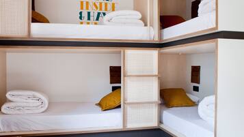 A multi-level bunk bed room with a 'COME INSIDE & HAVE FUN' sign, wooden furniture, and a patterned bench.