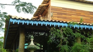 A traditional wooden house with a tiled roof and a blue decorative border. - Pousada Pilar (Arraial do Cabo)