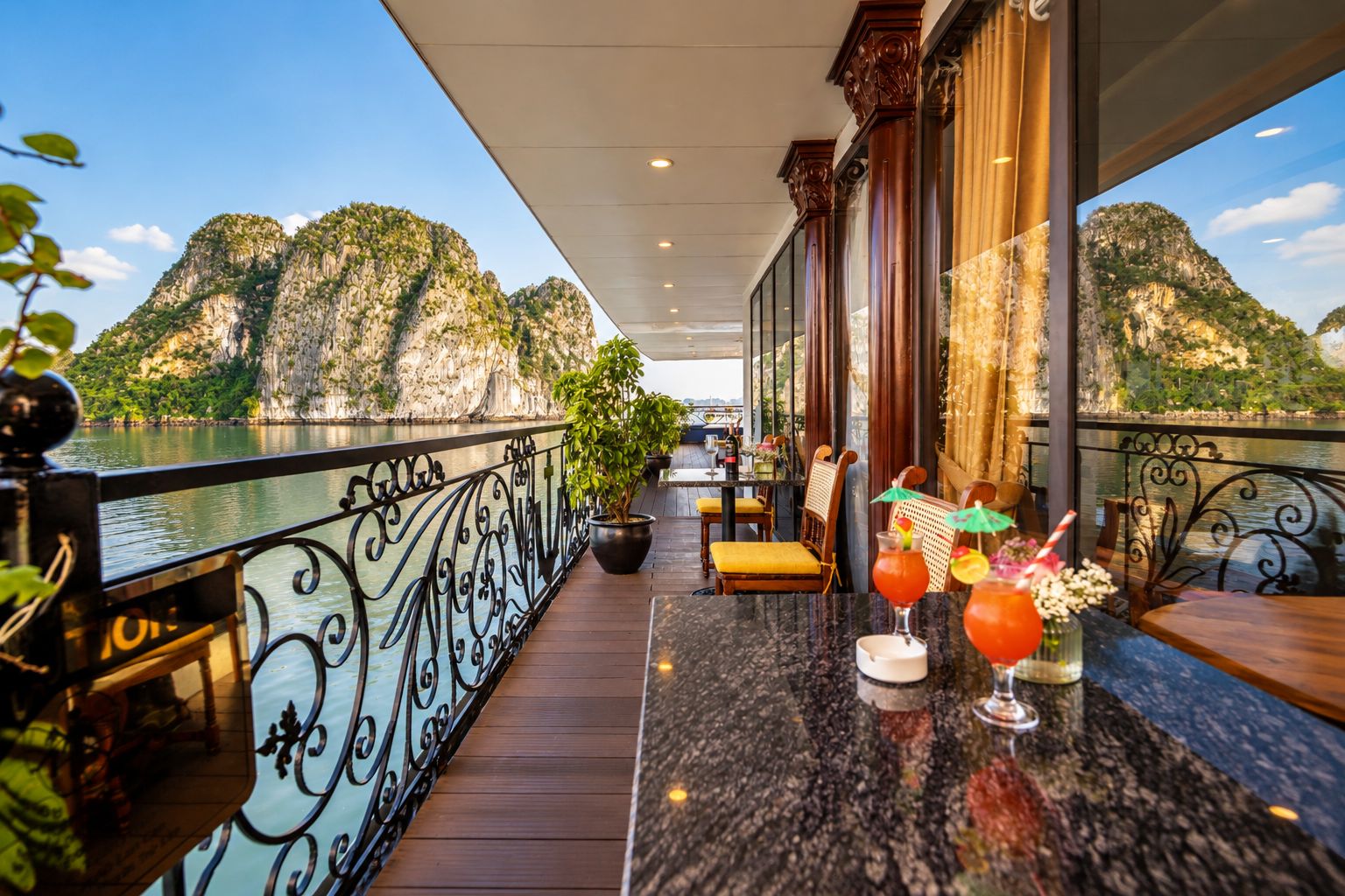 A balcony with a view of mountains and a bar area with drinks.