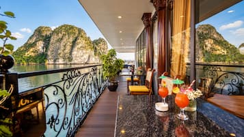 Un balcón con vistas a las montañas y una zona de bar con bebidas.