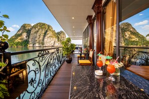 Varanda com vista para montanhas e área de bar com bebidas.