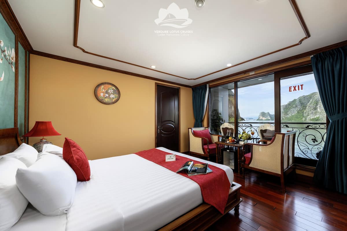 Una habitación de hotel con una cama, una mesa con vistas, una silla y una puerta.