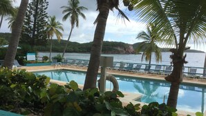 Un espace piscine avec des chaises longues et vue sur la mer.