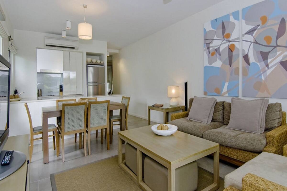 Ein modernes Wohnzimmer mit Sofa, Couchtisch und Essbereich.