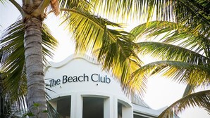 The Beach Club building with a white facade and palm trees in the foreground. - Beach Club Port Douglas 3 Bedroom Luxury Apartment (Port Douglas)