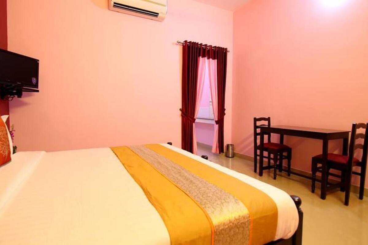 A hotel room with a bed, a desk, and a chair.